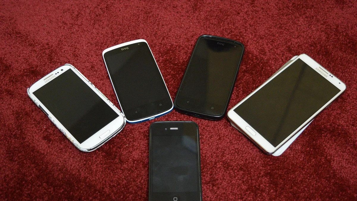 Photographie documentaire de smartphones, prise avant 2026. Illustration d'un type de bien de consommation ; elle ne représente aucun appareil ayant fait l'objet d'une réclamation. Photo : Kskhh ; CC BY-SA 4.0 ; recadrage editorial.
